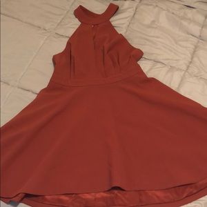 A semi formal mid length, deep/burnt coral dress.